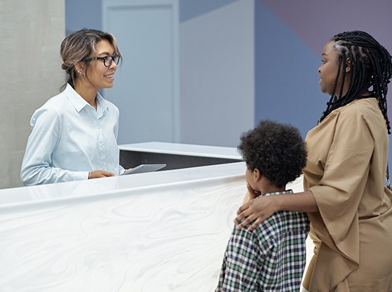 Mother and son talking to a receptionist