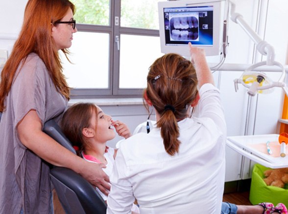 Pediatric dental team reviewing X-ray with child