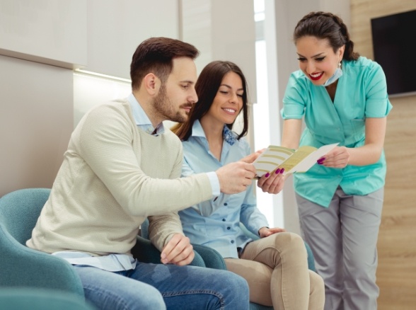 Dental team member explaining dental insurance to pediatric dentistry patient's parents