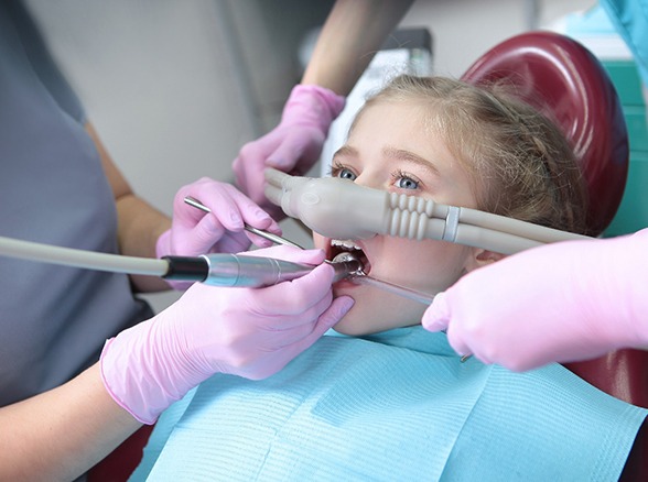 Child breathing in nitrous oxide during dental treatment