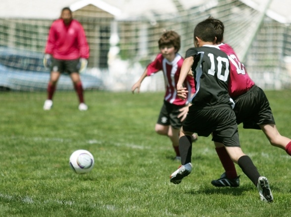 Kids playing soccer wearing athletic mouthguard