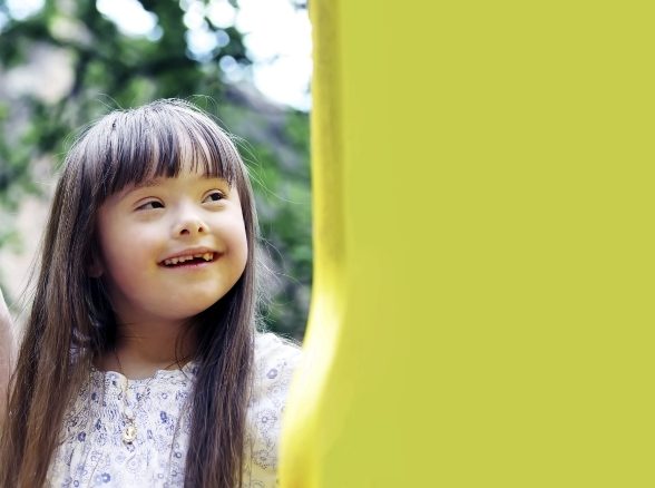 Child smiling outdoors after special needs dentistry