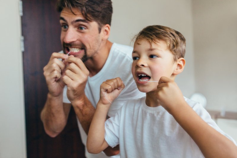 picture of a parent flossing with his child