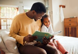 Father reading a book to his daughter